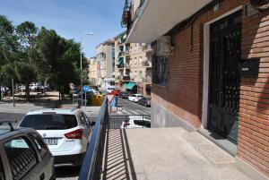 a white car parked on a sidewalk next to a building at Viviendas De Uso Turistico Rocinante TOLEDO in Toledo