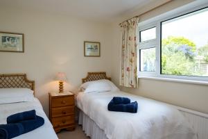two beds in a bedroom with a window at Pencreek in Padstow
