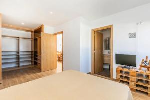 Schlafzimmer mit einem Bett und einem Flachbild-TV in der Unterkunft Moments Villa in Mafra