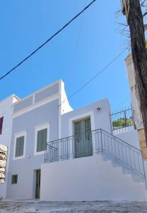 una casa blanca con una escalera delante en LA CASA DI MARCONI en Symi