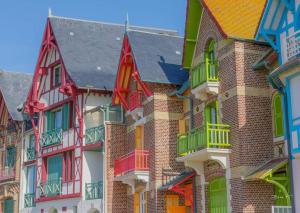 un grupo de casas con ventanas y balcones coloridos en A deux pas mer et falaises, en Mers-les-Bains