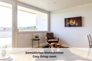 a living room with a chair and a fireplace at Auszeit Apartment ALPENBLICK in Oberteuringen +12 photos