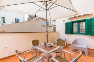 une table et des chaises sur un balcon avec un parasol dans l'établissement Starhost - Terazza Barbuti, à Salerne