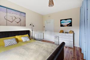 Modern and Spacious flat near Edinburgh في Prestonpans: غرفة نوم فيها سرير وخزانة