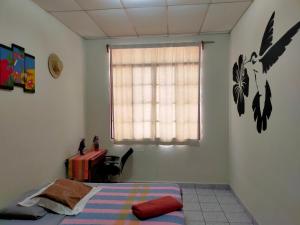 a bedroom with a bed and a window and a table at Matagalpa Tours Guest House in Matagalpa