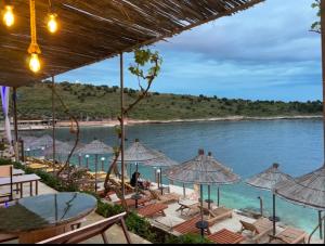 a view of a beach with chairs and umbrellas at Villa Xhefri 2 in Sarandë