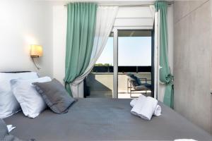 een slaapkamer met een bed met groene gordijnen en een balkon bij Grand Suite Cocaletto 2 in Rovinj