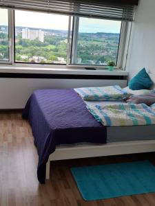 a bed in a room with a large window at IM SI-CENTRUM 2 ZIMMER APART#MUSICAL#MESSE#Flughafen in Stuttgart