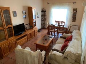 a living room with a couch and a tv at APARTAMENTO TURÍSTICO EL ESQUILÓN in Calzadilla