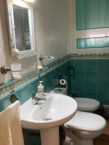 a bathroom with a sink and a toilet and a mirror at APARTAMENTO TURÍSTICO EL ESQUILÓN in Calzadilla +34 photos