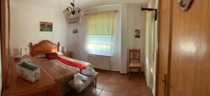 a bedroom with a bed and a window and a chair at APARTAMENTO TURÍSTICO EL ESQUILÓN in Calzadilla