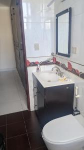 a bathroom with a white toilet and a sink at Moderno Departamento Céntrico c/ Wifi Empresarial in Tarija