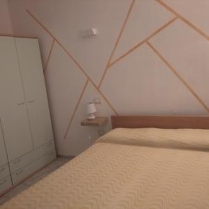 a bedroom with a bed and a geometric ceiling at Appartamento Ercole in Budoni