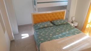 een kleine slaapkamer met een bed met een groen dekbed bij Villa-Hotel Ludianna in Golem