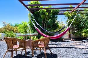 a patio with a hammock and a table and chairs at La casa de La Cartita in Puntagorda