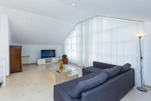 ein Wohnzimmer mit einem Sofa und einem Tisch in der Unterkunft PIZARRA Planetcostadorada in Tarragona