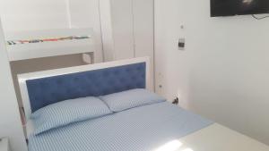 een bed met een blauw hoofdeinde in een kamer bij Villa-Hotel Ludianna in Golem