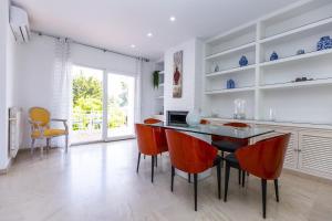 eine Küche mit einem Esstisch und orangefarbenen Stühlen in der Unterkunft PIZARRA Planetcostadorada in Tarragona