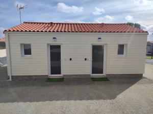 a small white building with a red roof at Studio meublé lumineux au coeur du bocage vendéen in Saint-Fulgent