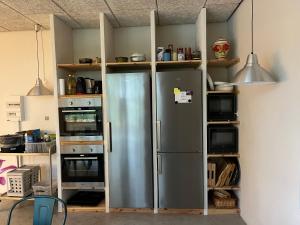una cucina con frigorifero in acciaio inossidabile di Room 16 - Hawkraft kulturhotel a Vestervig