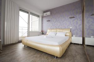 Un dormitorio con una cama grande y una pared azul. en Sea View Penthouse Mamaia, en Mamaia