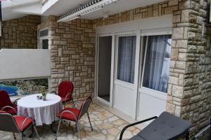a patio with a white door and a table and chairs at Draga & Lola in Baška Voda