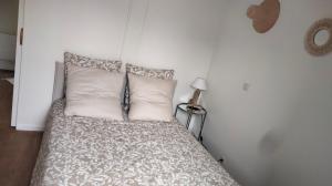 a bedroom with a bed with white sheets and pillows at Le Chalet in Mers-les-Bains