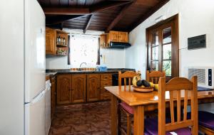 a kitchen with wooden cabinets and a wooden table at La casa de La Cartita in Puntagorda