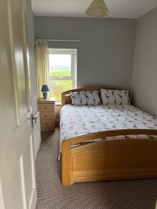 Un dormitorio con una cama grande y una ventana en The Rathmore House, en Roscommon