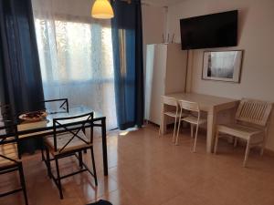cocina y comedor con mesa y sillas en Appartamento in Oasis tropicale en Corralejo
