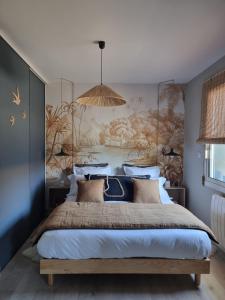 1 dormitorio con 1 cama grande y un mural en la pared en La Parenthèse du Las, en Saint-Jean-dʼIllac