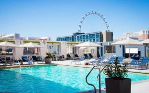 uma piscina com cadeiras e guarda-sóis num edifício em Condo at Platinum Hotel Strip View em Las Vegas
