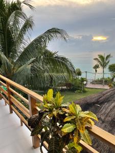 einen Balkon mit einer Bank, Palmen und Meerblick in der Unterkunft Villa de Gloria in Dauis
