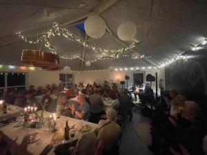 een groep mensen die aan tafel zitten in een restaurant bij Room 16 - Hawkraft kulturhotel in Vestervig