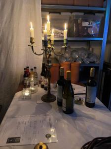 a table with bottles of wine and candles on it at Room 16 - Hawkraft kulturhotel in Vestervig
