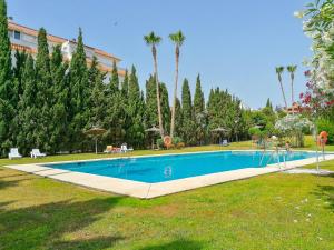 una piscina en un parque con palmeras en Casa Azul - San Luis de Sabinillas, en San Luis de Sabinillas