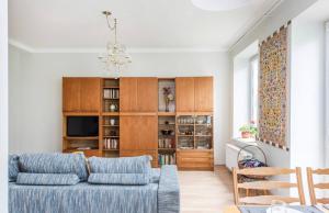 un soggiorno con divano blu e lampadario pendente di Vintage 2BED Condo-Prime Rentals a Vilnius