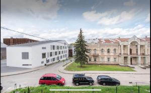 un gruppo di auto parcheggiate in un parcheggio di fronte a un edificio di Vintage 2BED Condo-Prime Rentals a Vilnius