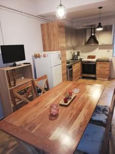 een keuken met een houten tafel en een witte koelkast bij Comfortable apartment for relax. in Volos