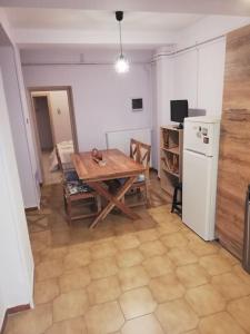 een keuken met een tafel en een witte koelkast bij Comfortable apartment for relax. in Volos