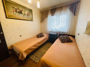 two beds in a small room with a window at Avelana Apartment in Pärnu