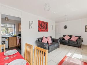 a living room with couches and a table and a kitchen at Self Catering Belfast Apartment in Belfast