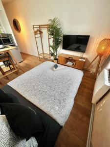 a living room with a table and a tv at Studio Douillet Hypercentre 12 min de Paris in Enghien-les-Bains