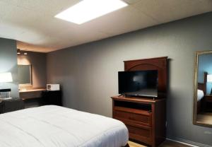 a bedroom with a bed and a flat screen tv at Executive Inn in Mena