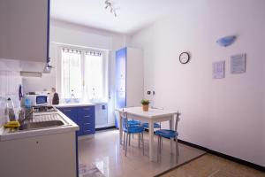 a kitchen with a sink and a table and chairs at La Casetta Blu in Genoa