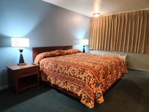 a bedroom with a bed and two lamps on a table at Executive Inn in Mena +26 photos
