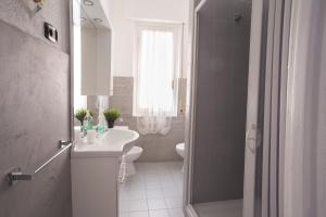 a white bathroom with a sink and a toilet at La Casetta Blu in Genoa