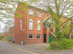 um edifício de tijolos vermelhos com uma escada em frente em Self Catering Belfast Apartment em Belfast