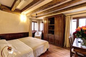 Un dormitorio con una cama y una mesa con un jarrón de flores en Palazzo La Scala, en Venecia
