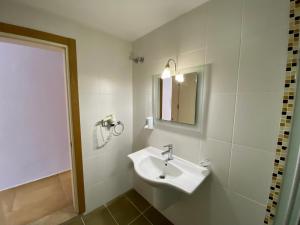 La salle de bains blanche est pourvue d'un lavabo et d'un miroir. dans l'établissement Konfor Suite Otel, à Ölüdeniz